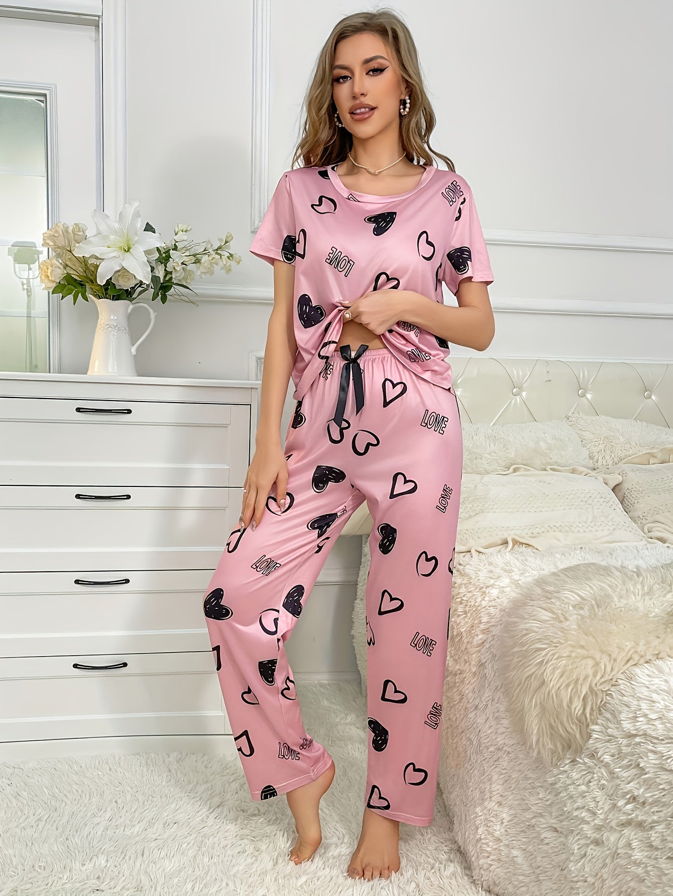 An adorable pink heart and letter print Women's pajama set, featuring a short-sleeve round-neck top paired with long pants, soft and comfortable