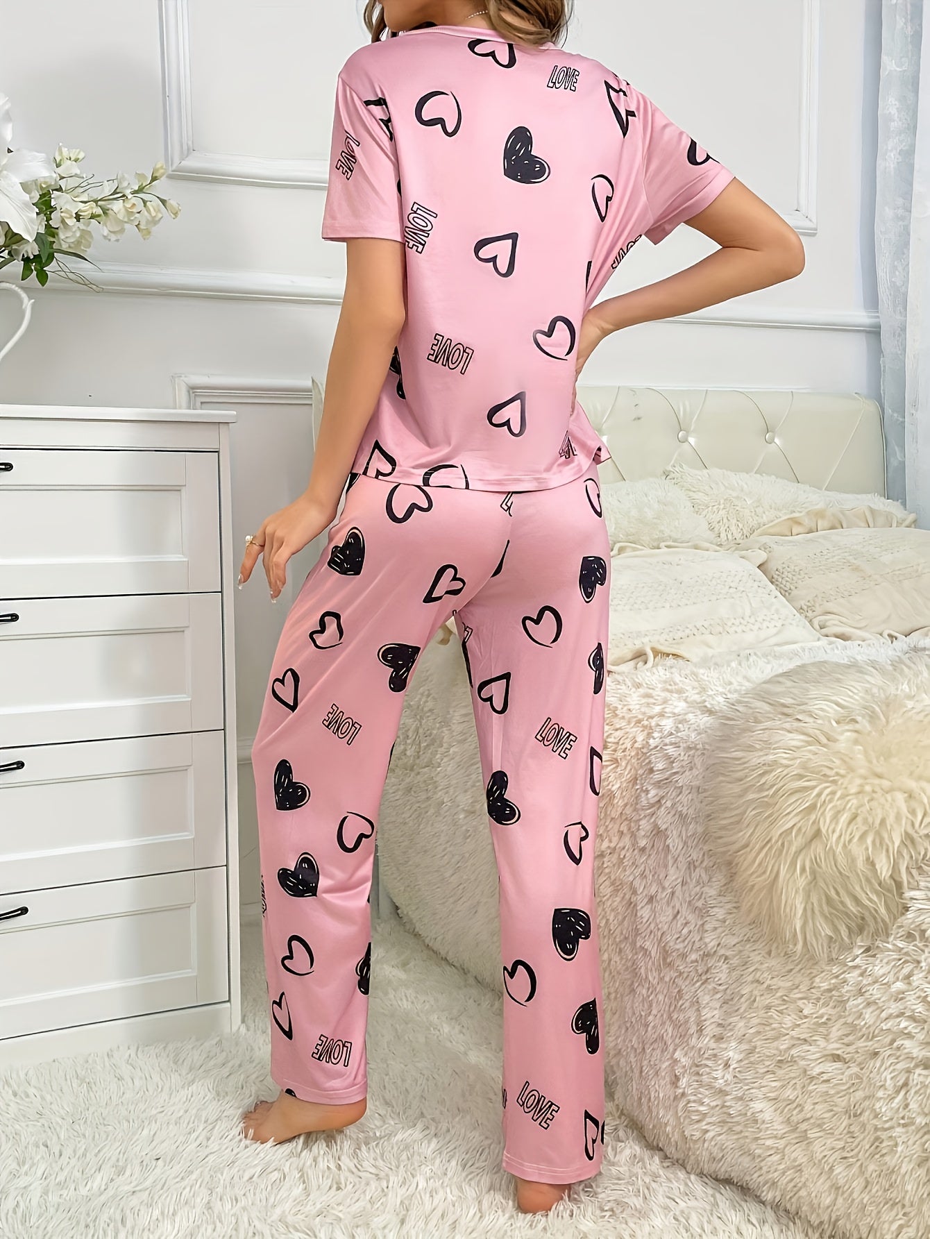 An adorable pink heart and letter print Women's pajama set, featuring a short-sleeve round-neck top paired with long pants, soft and comfortable